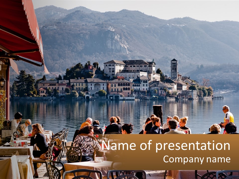 A Group Of People Sitting At A Table In Front Of A Lake PowerPoint Template