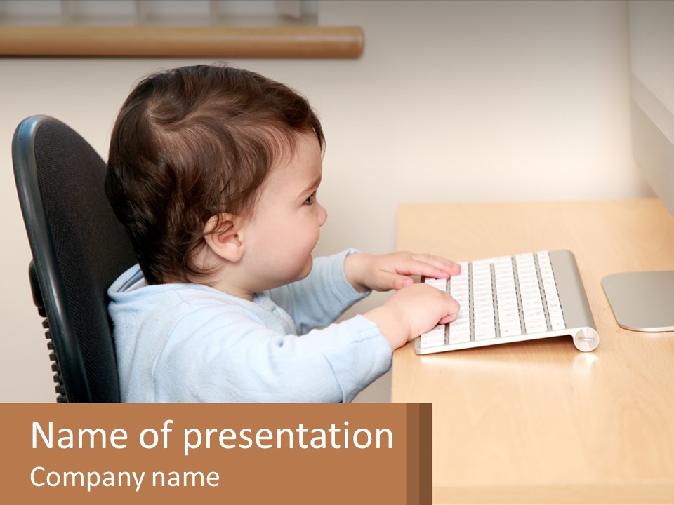 A Young Child Using A Laptop Computer At A Desk PowerPoint Template