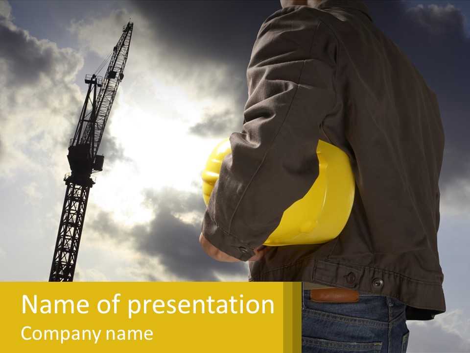 A Man Holding A Yellow Safety Helmet In Front Of A Crane PowerPoint Template