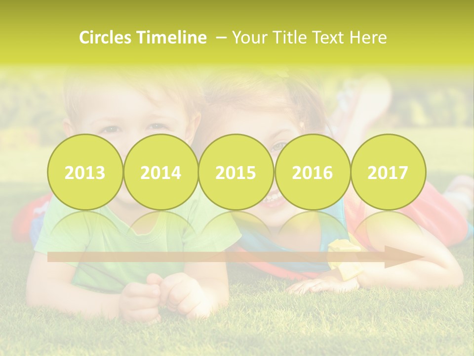 Two Young Children Laying On The Grass In A Park PowerPoint Template