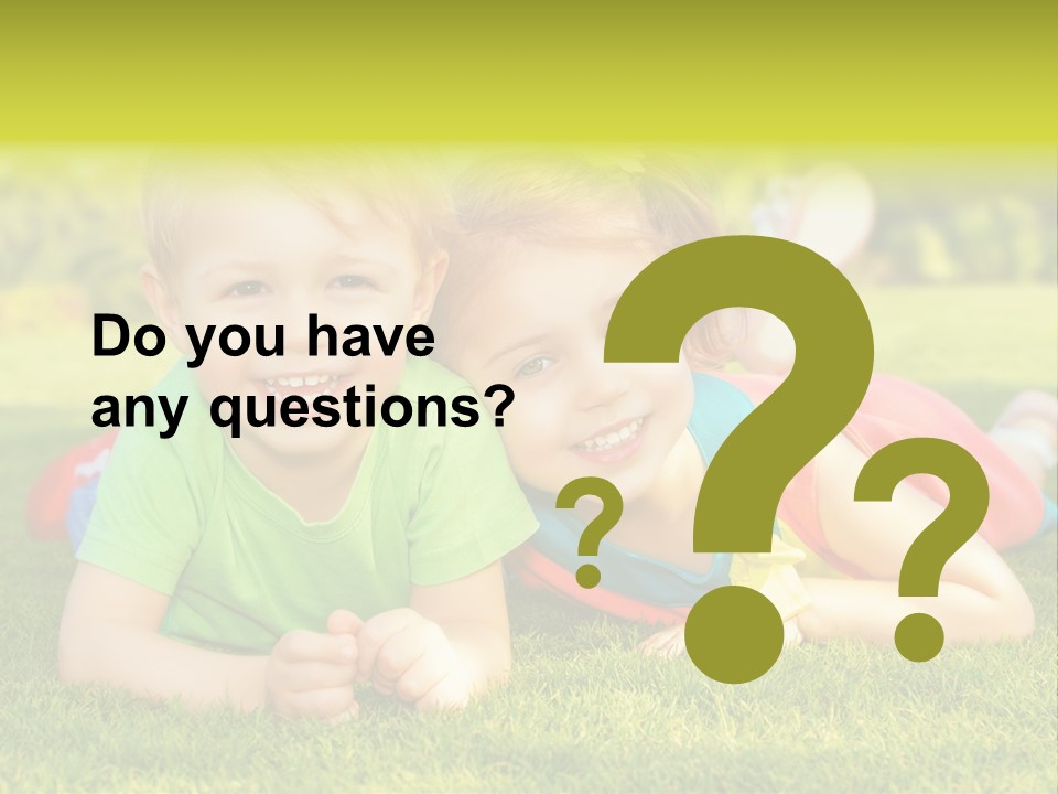 Two Young Children Laying On The Grass In A Park PowerPoint Template