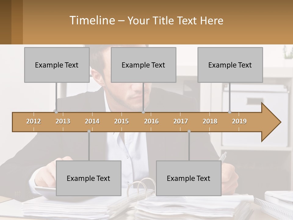 A Man Sitting At A Desk Writing On A Piece Of Paper PowerPoint Template
