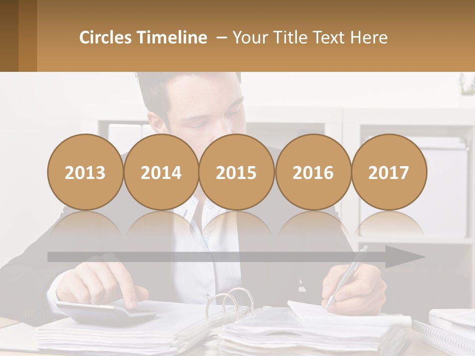 A Man Sitting At A Desk Writing On A Piece Of Paper PowerPoint Template