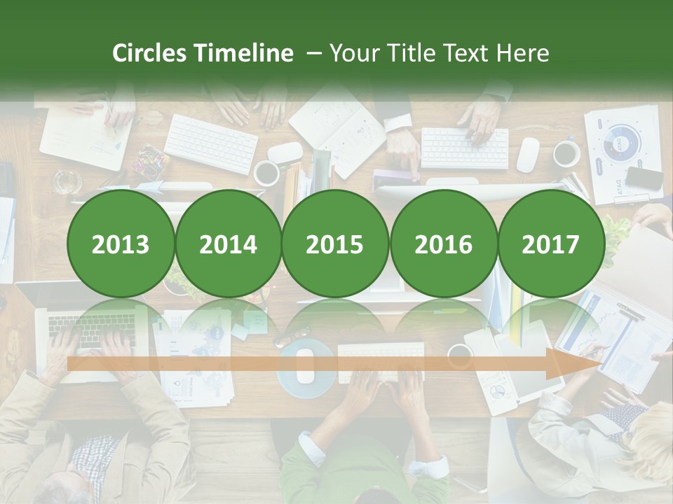 A Group Of People Sitting At A Table Working On Laptops PowerPoint Template