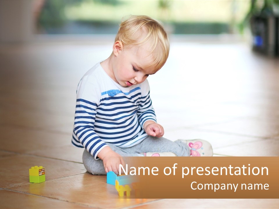 A Small Child Playing With Toys On The Floor PowerPoint Template