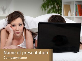 A Woman Laying In Bed Next To A Laptop Computer PowerPoint Template
