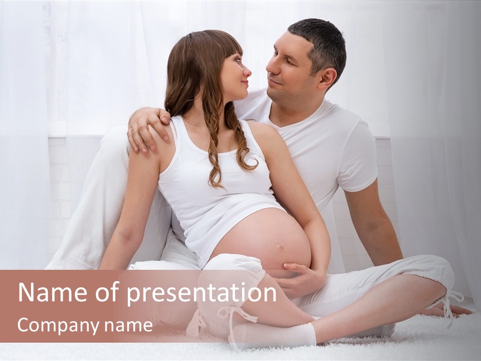 A Pregnant Couple Sitting On A Bed Together PowerPoint Template