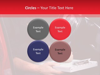 A Man Sitting In A Red Car Writing On A Clipboard PowerPoint Template