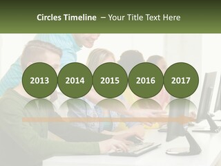 A Group Of People Sitting At A Computer Desk PowerPoint Template