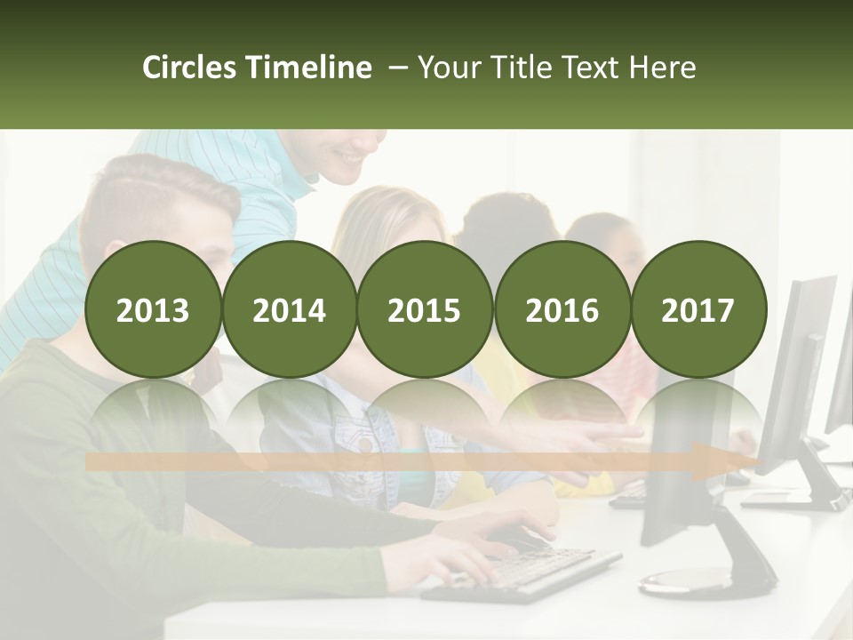 A Group Of People Sitting At A Computer Desk PowerPoint Template