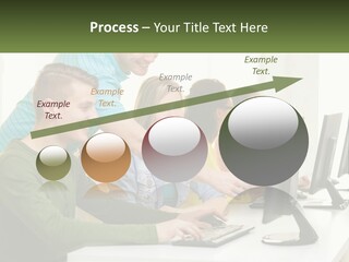A Group Of People Sitting At A Computer Desk PowerPoint Template