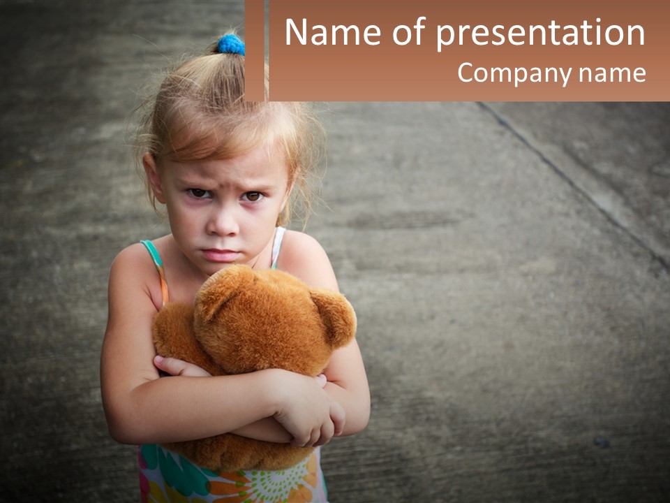 A Little Girl Holding A Teddy Bear In Her Arms PowerPoint Template