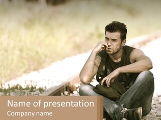 A Man Sitting On A Train Track Talking On A Cell Phone PowerPoint Template