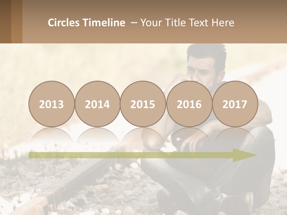 A Man Sitting On A Train Track Talking On A Cell Phone PowerPoint Template