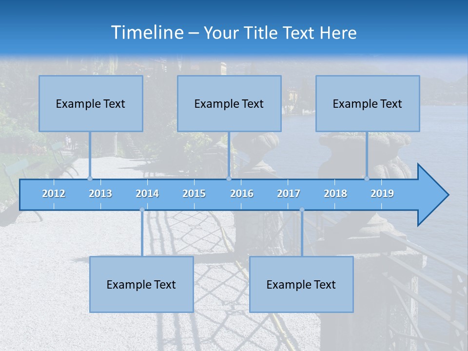 A Stone Walkway Next To A Body Of Water With Mountains In The Background PowerPoint Template