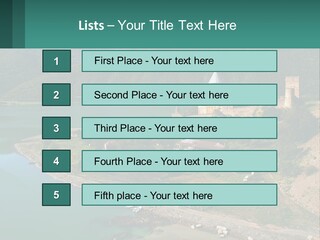 A Large Castle Sitting On Top Of A Lush Green Hillside PowerPoint Template