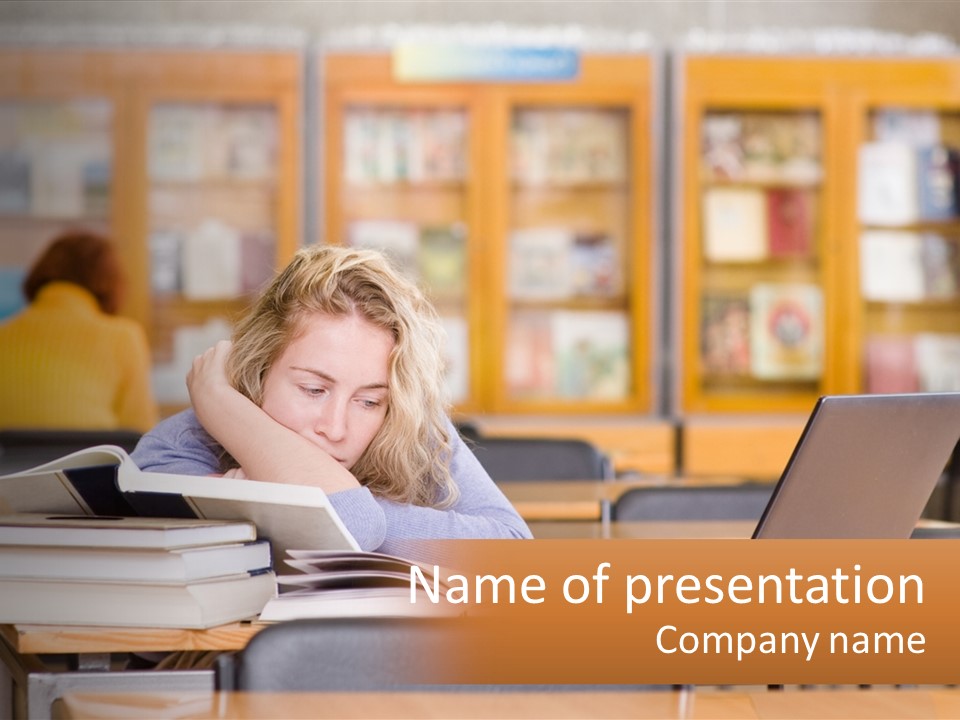A Woman Sitting At A Desk With A Laptop Computer PowerPoint Template