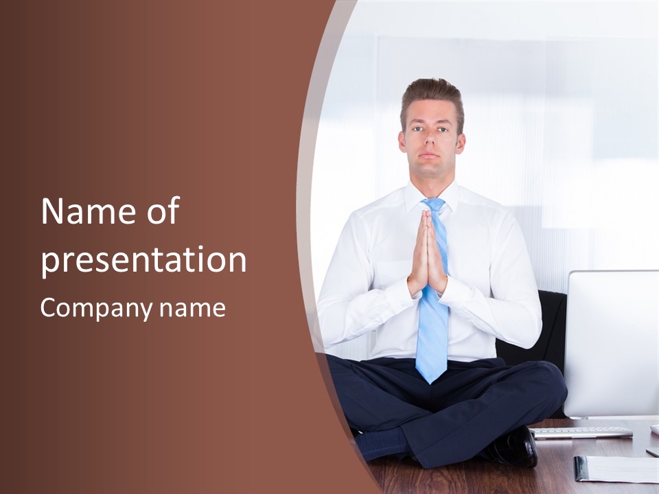 A Man Sitting On A Desk With His Hands Folded In Front Of Him PowerPoint Template