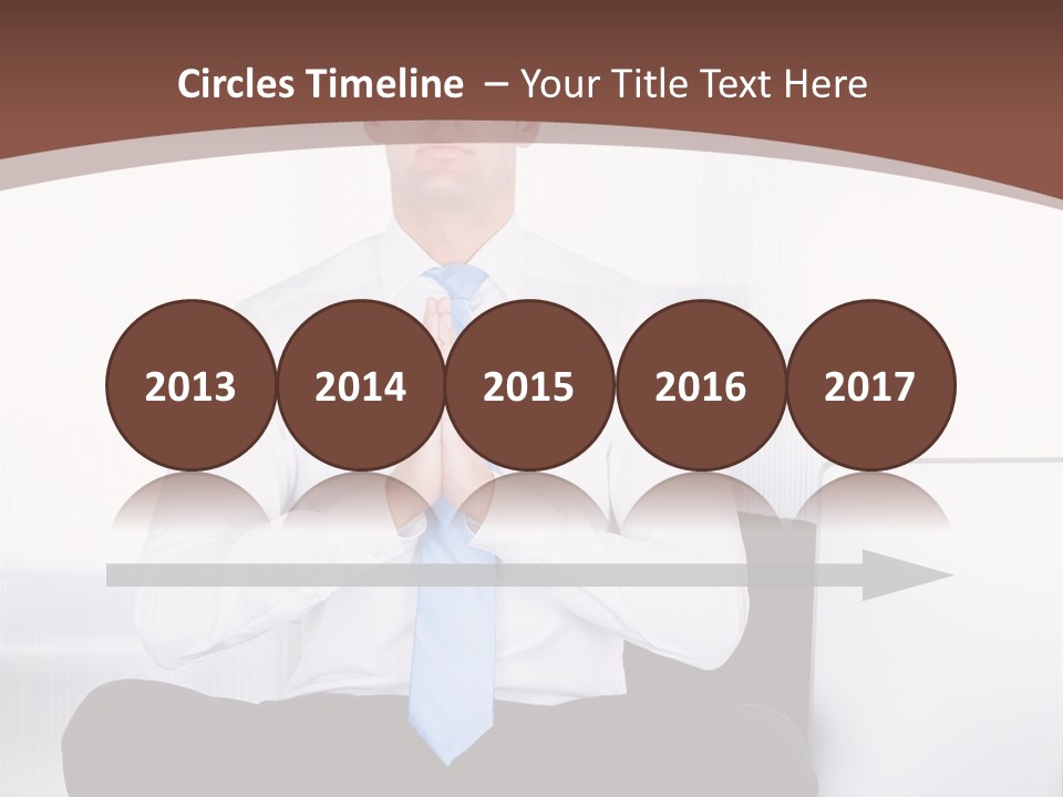 A Man Sitting On A Desk With His Hands Folded In Front Of Him PowerPoint Template