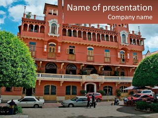 A Large Building With Cars Parked In Front Of It PowerPoint Template