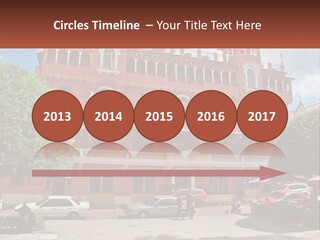 A Large Building With Cars Parked In Front Of It PowerPoint Template