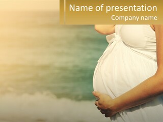 A Pregnant Woman Standing In Front Of A Body Of Water PowerPoint Template