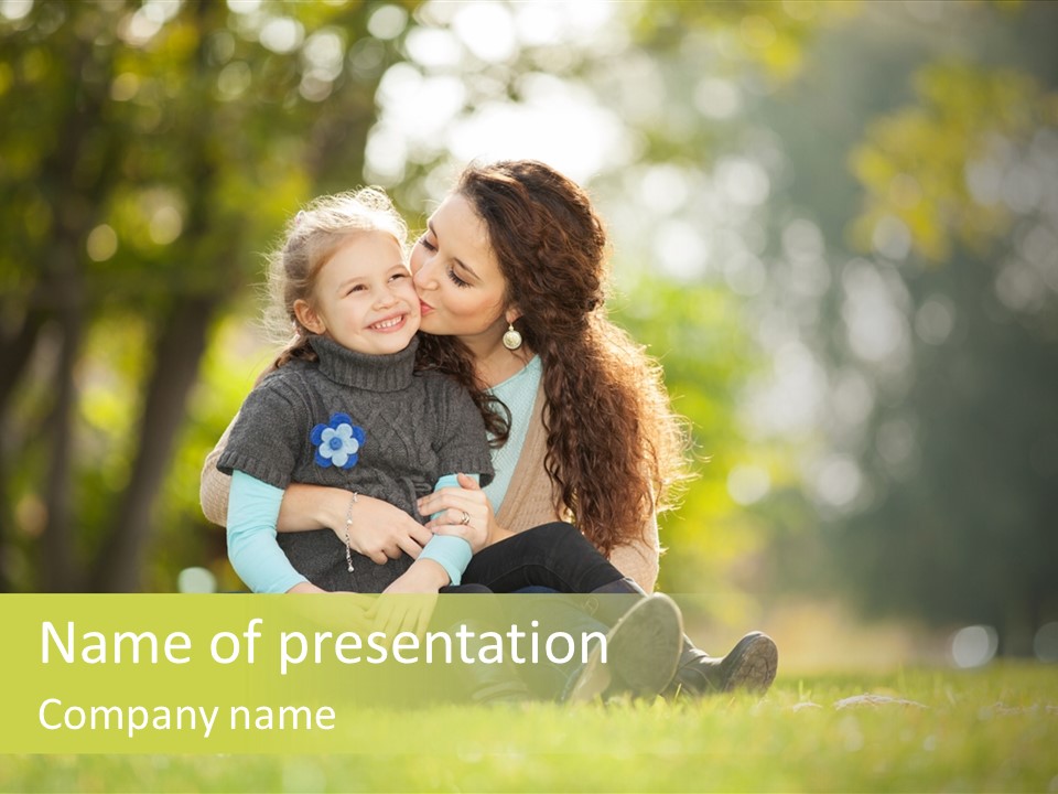 A Woman And A Child Are Sitting In The Grass PowerPoint Template