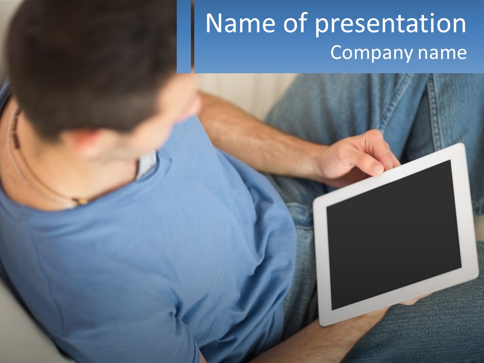 A Man Sitting On A Couch Holding A Tablet PowerPoint Template