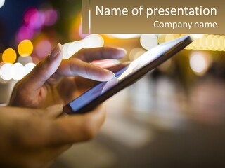 A Person Using A Cell Phone In A City At Night PowerPoint Template