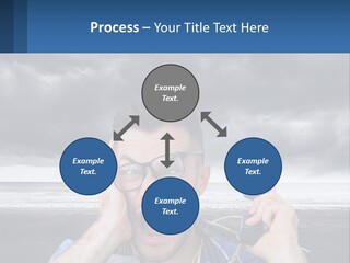 A Man Holding A Cell Phone Up To His Face PowerPoint Template