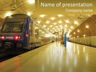 A Blue Train Pulling Into A Train Station PowerPoint Template