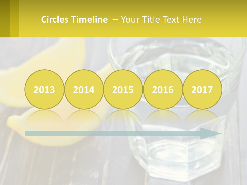 A Glass Of Water With Lemons On A Wooden Table PowerPoint Template