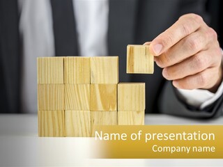 A Business Man Stacking Wooden Blocks On Top Of A Table PowerPoint Template