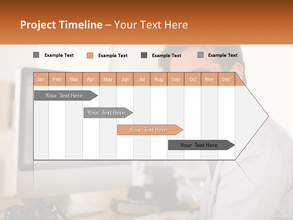 A Man Sitting At A Desk In Front Of A Computer PowerPoint Template