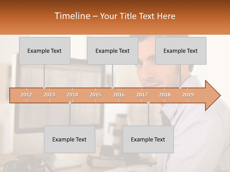 A Man Sitting At A Desk In Front Of A Computer PowerPoint Template