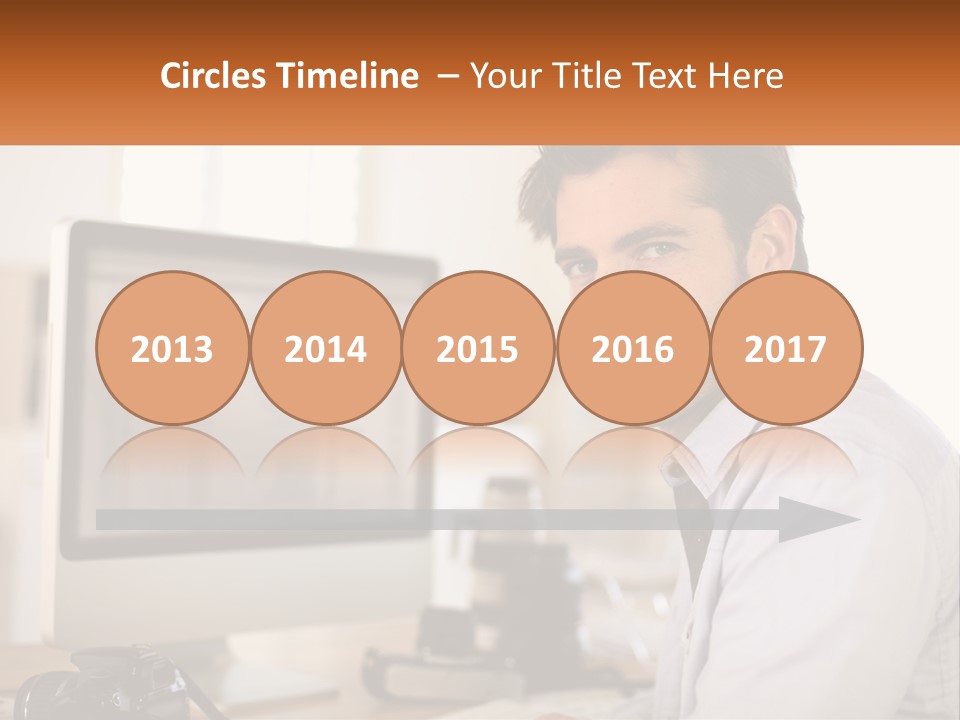 A Man Sitting At A Desk In Front Of A Computer PowerPoint Template