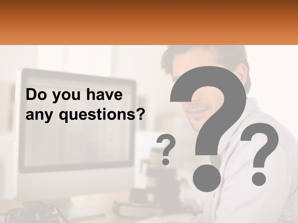 A Man Sitting At A Desk In Front Of A Computer PowerPoint Template