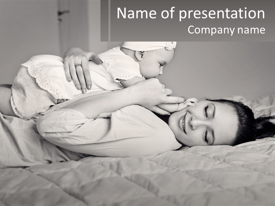 A Woman Laying On Top Of A Bed Holding A Baby PowerPoint Template