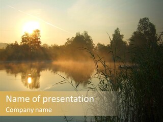 The Sun Is Setting Over A Lake With Reeds In The Foreground PowerPoint Template