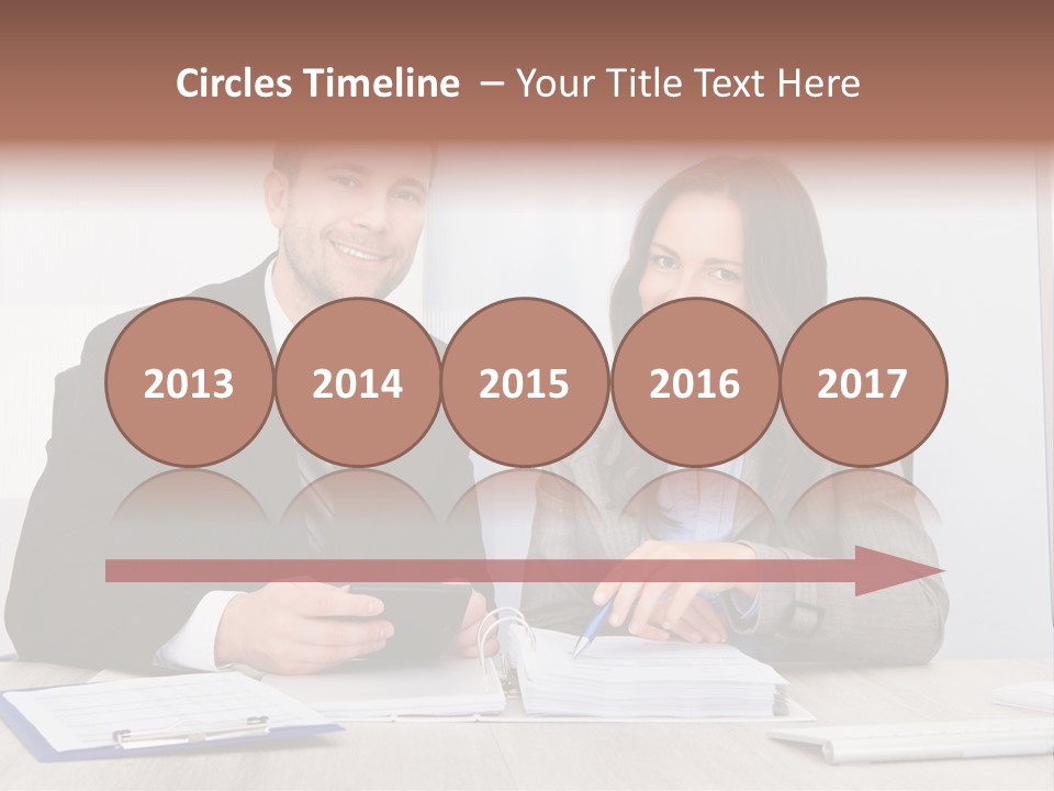 A Man And A Woman Sitting At A Desk PowerPoint Template