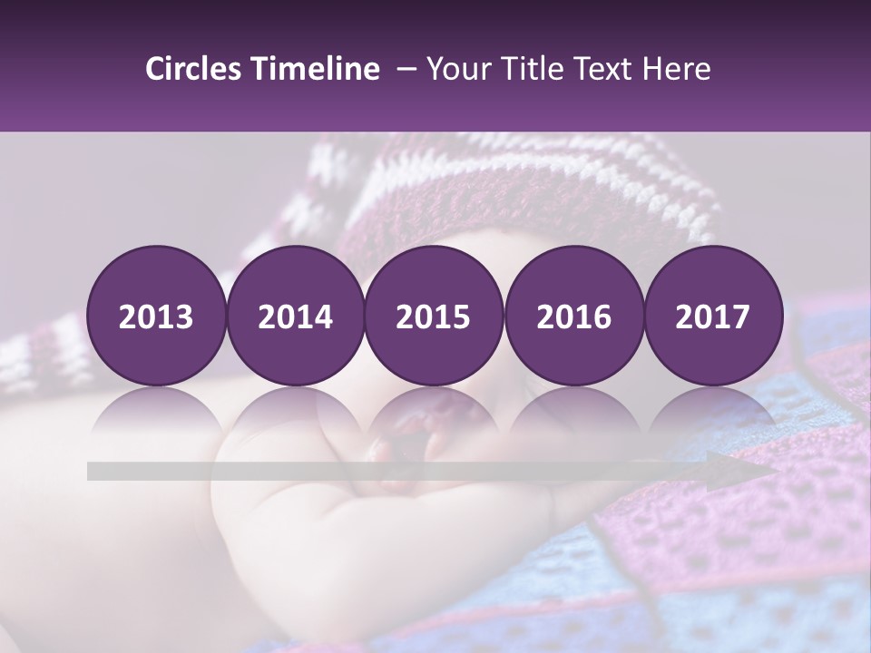 A Baby Wearing A Knitted Hat Laying On A Blanket PowerPoint Template