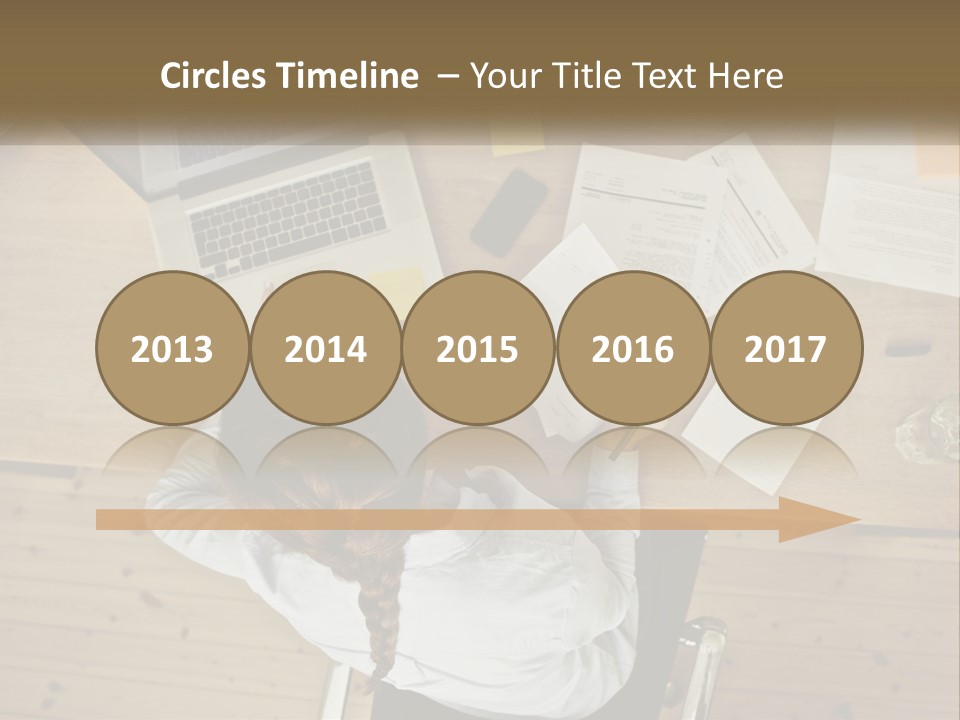 A Woman Sitting At A Table With A Laptop And Papers PowerPoint Template