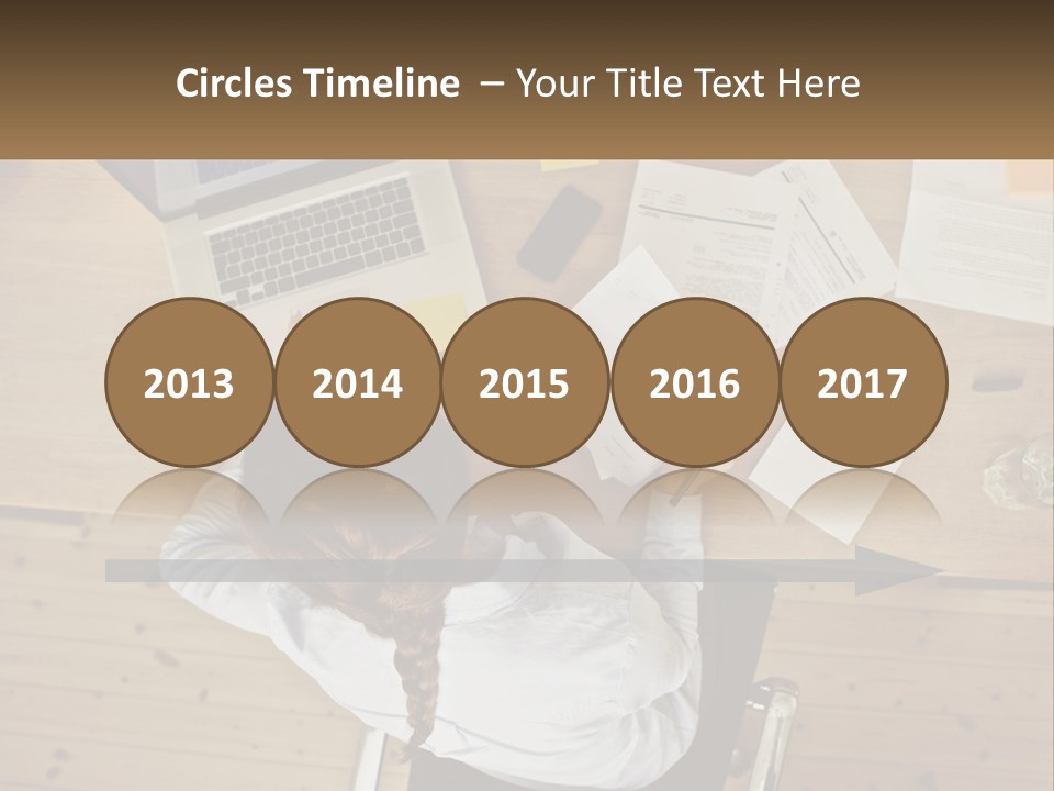 A Woman Sitting At A Desk With A Laptop And Papers PowerPoint Template