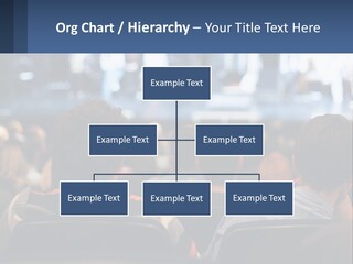 A Group Of People Sitting In Front Of A Stage PowerPoint Template