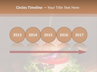 A Hamburger With Lettuce, Tomato, Onion And Cheese On A Cutting Board PowerPoint Template