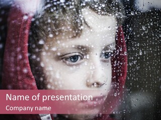 A Young Boy Looking Out Of A Window Covered In Snow PowerPoint Template