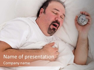 A Man Sleeping In Bed With A Clock In His Hand PowerPoint Template