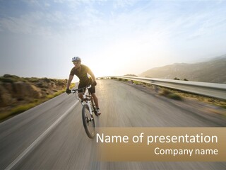 A Man Riding A Bike Down A Road PowerPoint Template