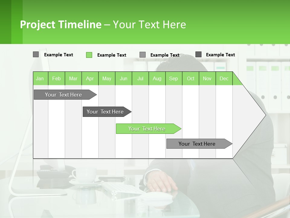 A Man Sitting At A Desk In Front Of A Computer PowerPoint Template