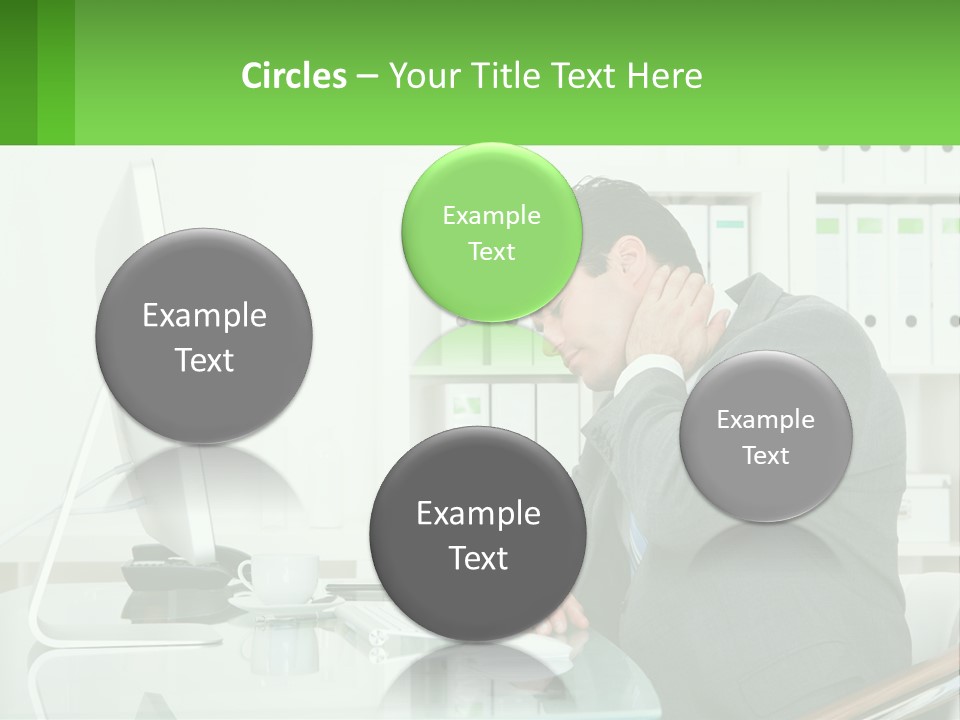 A Man Sitting At A Desk In Front Of A Computer PowerPoint Template
